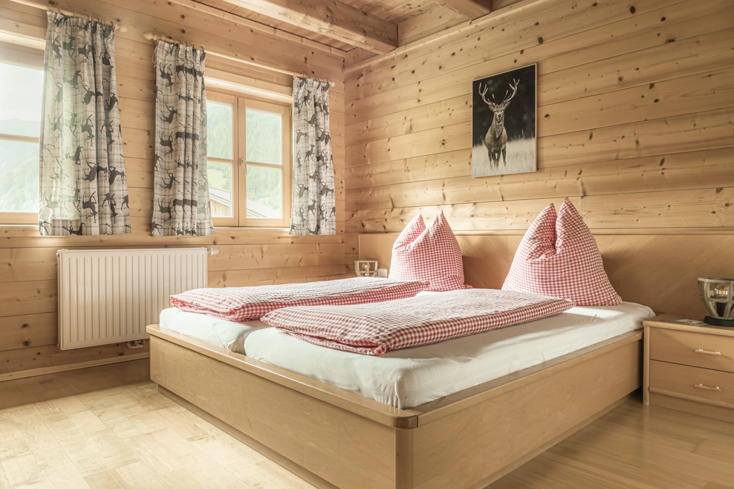 Schlafzimmer mit Doppelbett und Hirschbild