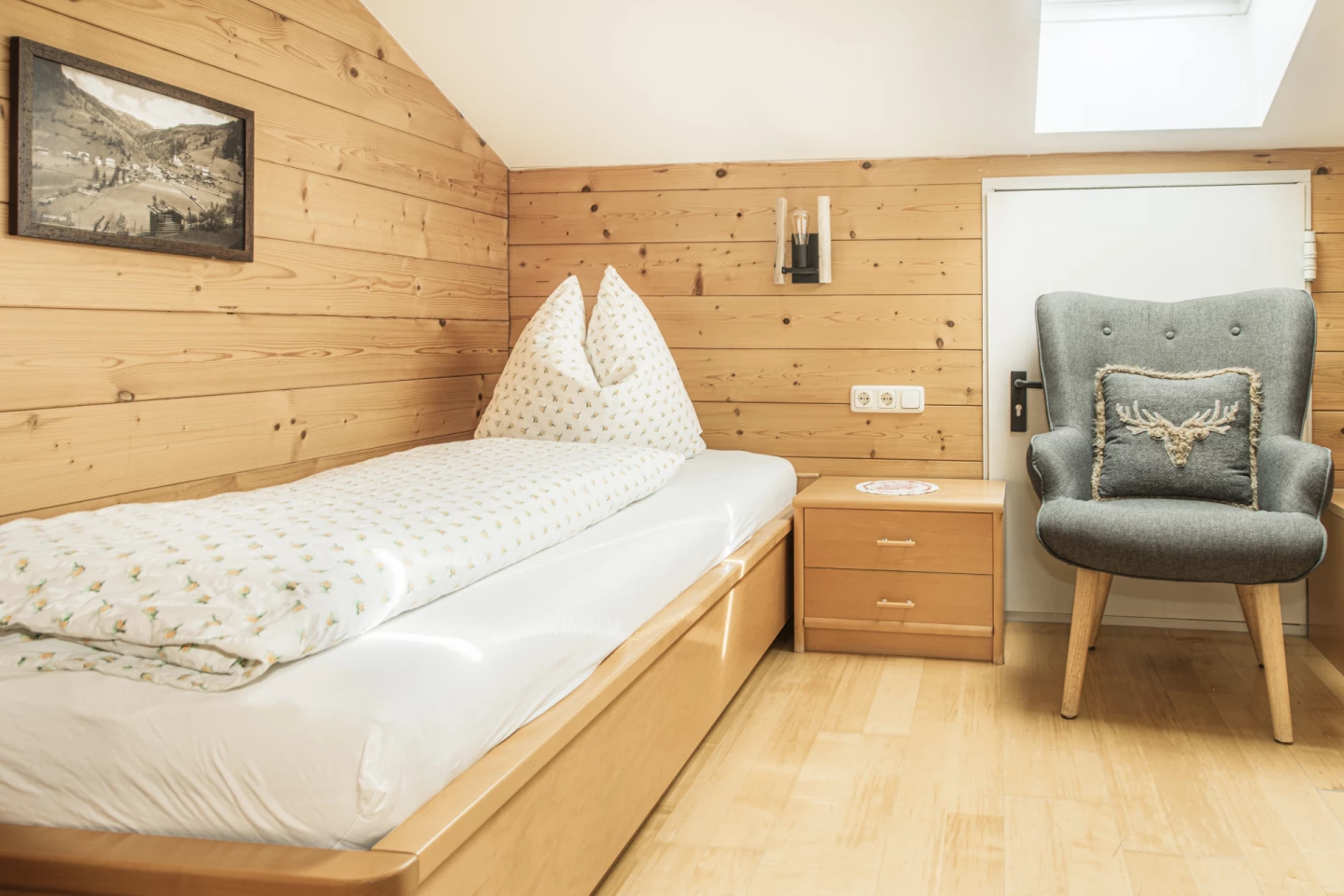 Zimmer mit Einzelbett und Lesesessel